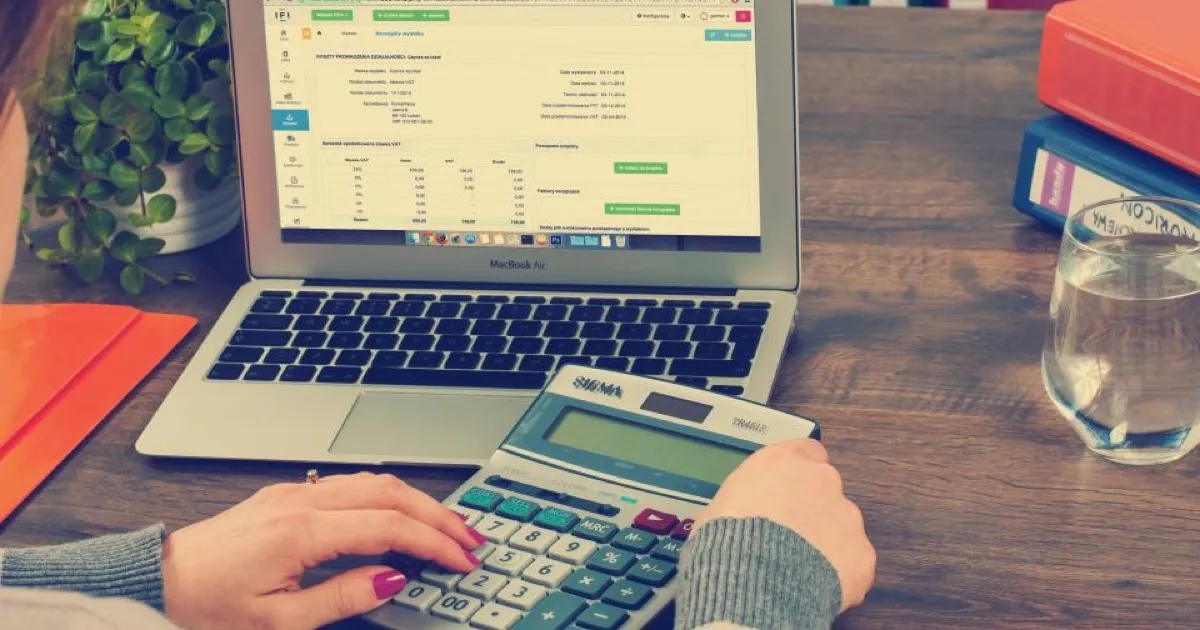A calculator and a stack of invoices representing the cost of manual reconciliation
